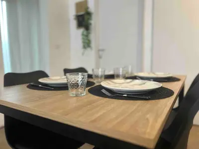 a wooden table with plates and glasses on top of it at Appartement proche centre ville in Castres