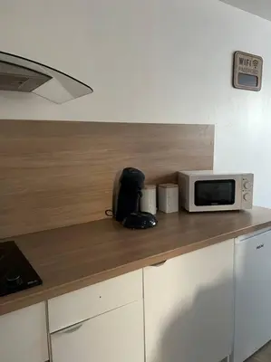 a kitchen counter with a microwave on top of it at Appartement proche centre ville in Castres