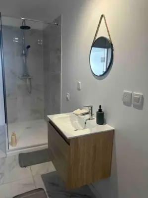 a bathroom with a sink and a shower and a mirror at Appartement proche centre ville in Castres