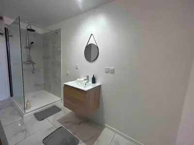 a bathroom with a shower and a sink and a mirror at Appartement proche centre ville in Castres