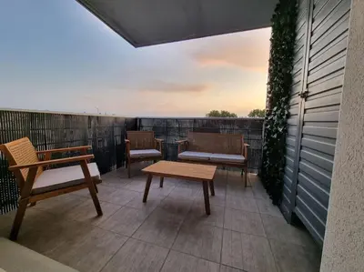 a patio with benches and tables on a balcony at L'Appartement Ensoleillé, WIFI-Clim-Gare-Terrasse in Narbonne
