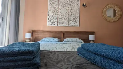 a bedroom with two beds with blue blankets and a mirror at Grande maison Carpediem, le calme à la campagne in Cassaignes