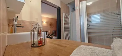 a kitchen with a counter top with a bathroom with a tub at Grande maison Carpediem, le calme à la campagne in Cassaignes
