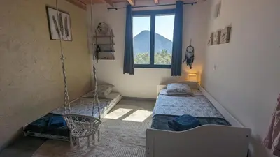 two beds in a room with a window at Grande maison Carpediem, le calme à la campagne in Cassaignes