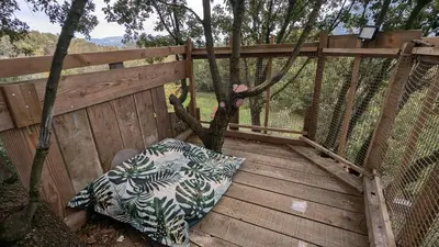 a wooden deck with a pillow and a fence at Grande maison Carpediem, le calme à la campagne in Cassaignes