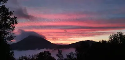 a sunset with a mountain in the background at Grande maison Carpediem, le calme à la campagne in Cassaignes