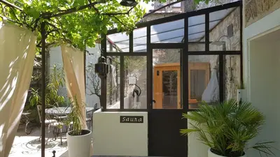 a small greenhouse with a door and potted plants at La Demeure du Pressoir in Cuxac-dʼAude