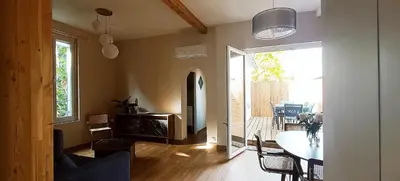 a living room with a table and a dining room at La Maison de Jeanne in Narbonne