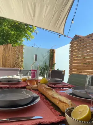 a table with plates and glasses and a bottle of wine at La Maison de Jeanne in Narbonne