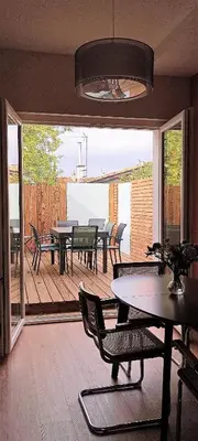 a dining room with tables and chairs on a deck at La Maison de Jeanne in Narbonne