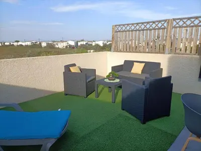 a patio with two chairs and a table on a balcony at L'hippocampe in Gruissan