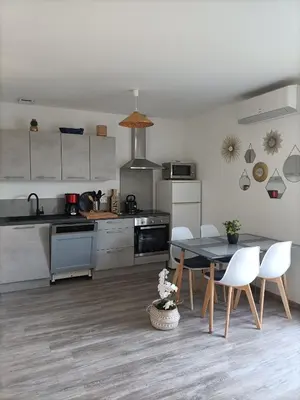 a kitchen with a table and chairs in a room at L'hippocampe in Gruissan