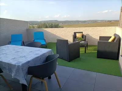 a room with a table and chairs on a patio at L'hippocampe in Gruissan