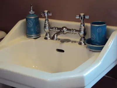 a bathroom sink with two blue cups on it at Les Chambres des Dames in Rieux-Minervois