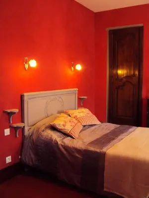 a bedroom with a bed with red walls at Les Chambres des Dames in Rieux-Minervois