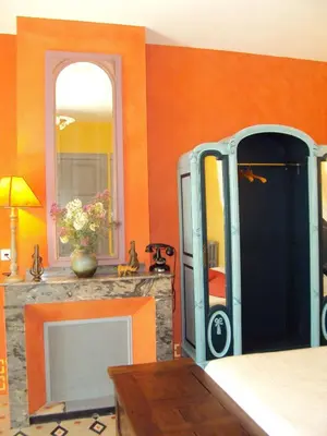 a living room with a fireplace and a mirror at Les Chambres des Dames in Rieux-Minervois