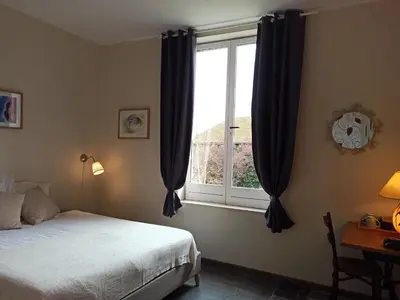 a bedroom with a bed and a window at LE DINANGA in Léran