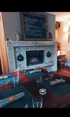 a wooden table with a fireplace in a room at LE DINANGA in Léran