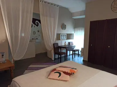 a bedroom with a bed and a table in a room at LE DINANGA in Léran