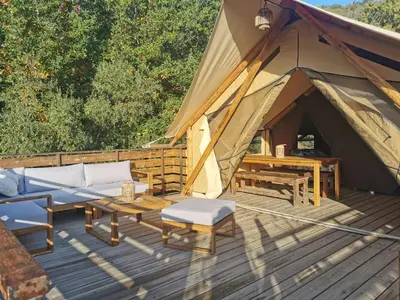 a tent with a couch and a table in front at Le lodge cocooning in Ansignan