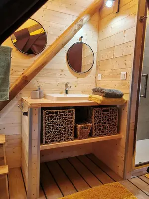 a bathroom with a sink in a wooden house at Le lodge cocooning in Ansignan
