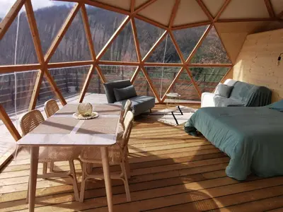 a room with a table and a bed and a large window at Le dôme géodésique in Ansignan