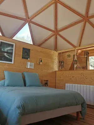 a bed in a room with wooden walls at Le dôme géodésique in Ansignan