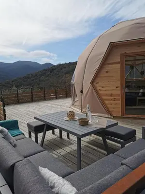 a wooden deck with a table and a tent at Le dôme géodésique in Ansignan