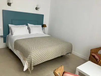 a bedroom with a large bed with a blue headboard at Appartement calme centre ville à 80m des Halles in Narbonne