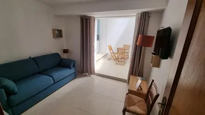 a living room with a blue couch and a balcony at Appartement calme centre ville à 80m des Halles in Narbonne