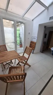 two wooden chairs and a table on a patio at Appartement calme centre ville à 80m des Halles in Narbonne