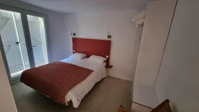 a bedroom with a bed with a red headboard at Appartement calme centre ville à 80m des Halles in Narbonne