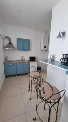 a kitchen with blue cabinets and two chairs and a counter at Appartement calme centre ville à 80m des Halles in Narbonne