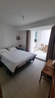 a bedroom with a bed and a view of a patio at Appartement calme centre ville à 80m des Halles in Narbonne