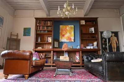 a living room with leather furniture and a chandelier at Chateau de Montcuquet in Lautrec