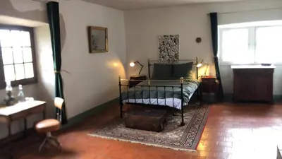 a bedroom with a bed and a table and windows at Chateau de Montcuquet in Lautrec