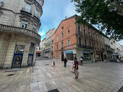 a group of people walking down a city street at Cours République in Narbonne