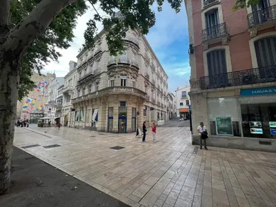 a group of people walking down a city street at Cours République in Narbonne