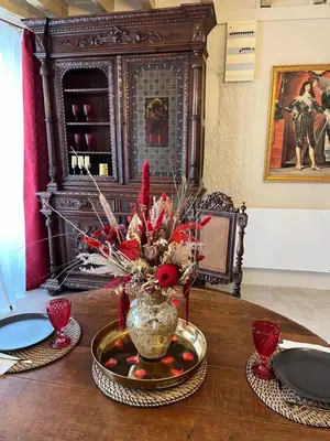 a table with a vase of flowers on a table at La Halte Louis XIII in Bram