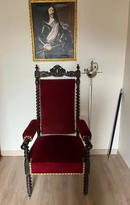 a chair in a room with a painting on the wall at La Halte Louis XIII in Bram
