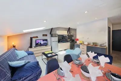 a kitchen with white cabinets and a red lamp at Le Barral in Castres