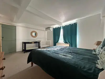 a bedroom with a large bed and a window at VILLA AU CALME AVEC PISCINE in Moussan