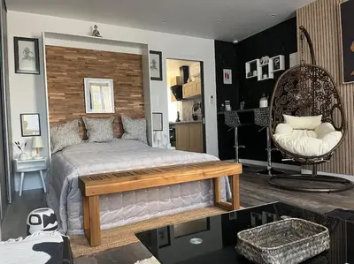 a bedroom with a large bed and a chair at jouxtant le canal du midi in Trèbes