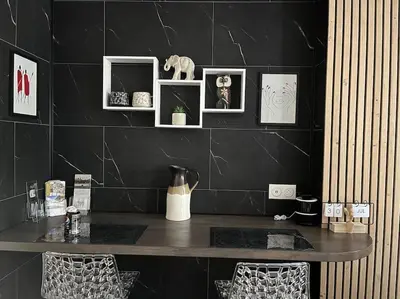 a black wall with a table with pictures on it at jouxtant le canal du midi in Trèbes