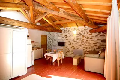 a living room with a table and a kitchen at Castel chambres in Malves-en-Minervois