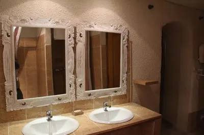 two sinks in a bathroom with two mirrors at Castel chambres in Malves-en-Minervois