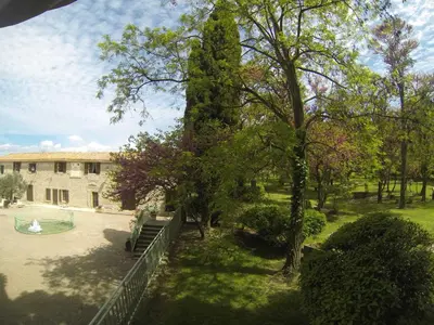 a park with a bench and a large tree at Castel chambres in Malves-en-Minervois