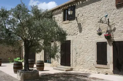 a stone building with a tree in front of it at Castel chambres in Malves-en-Minervois