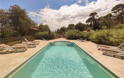 a swimming pool with chaises and chairs in a yard at 5 Bedroom Beautiful Home In Ouveillan in Ouveillan