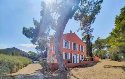 an orange house with a tree in front of it at 5 Bedroom Beautiful Home In Ouveillan in Ouveillan
